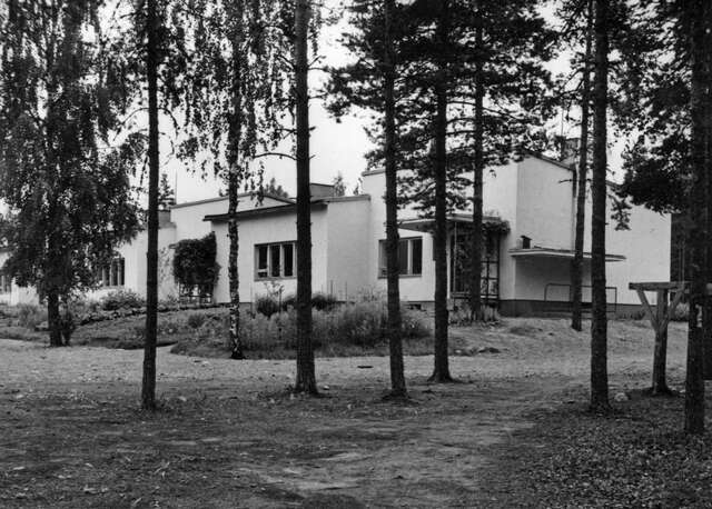 Functionalist row house surrounded by woods.