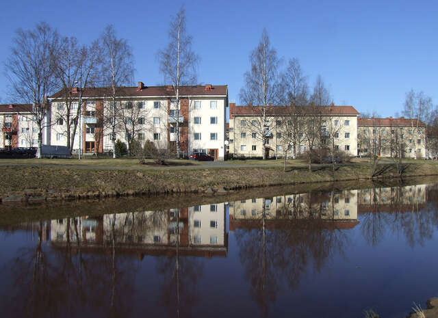 A river, on the opposite shore residential buildings