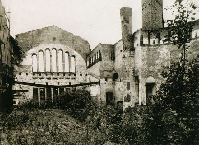 Old picture of the abandoned church without a roof and plants growing inside it.