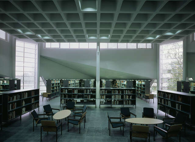Dark library with a sitting a rea in the middle.
