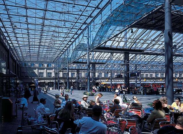 Passenges sitting at a cafe under the platform roofing