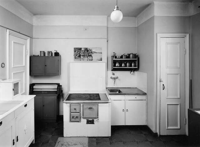 Light shaded kitchen, drawers, a stove and a ceiling light