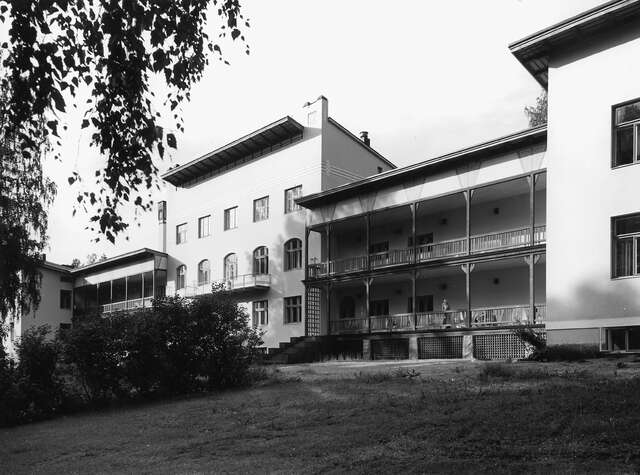 BW photograph of a hospital with green surroundings