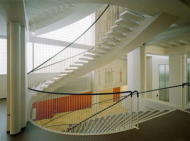 Spiral staircase with white metal railing.