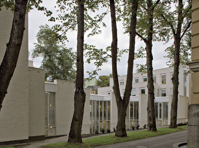 Inner courtyard with large window walls on the curtsied facade.