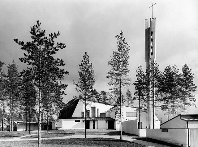 Black and white picture of the church exterior with its tower.