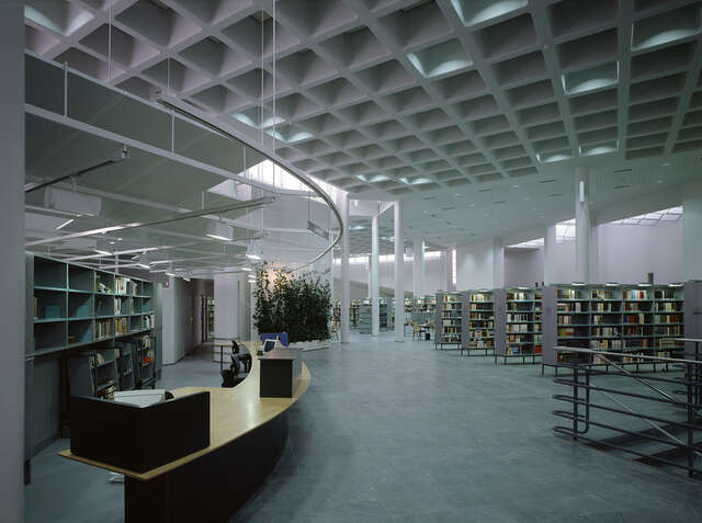 Bookshelves next to. curved lending desk.