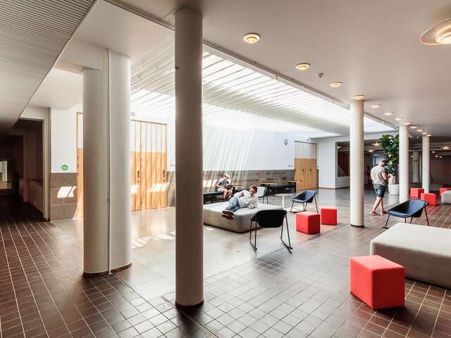 Seating area in the hallway with shite support pillars.