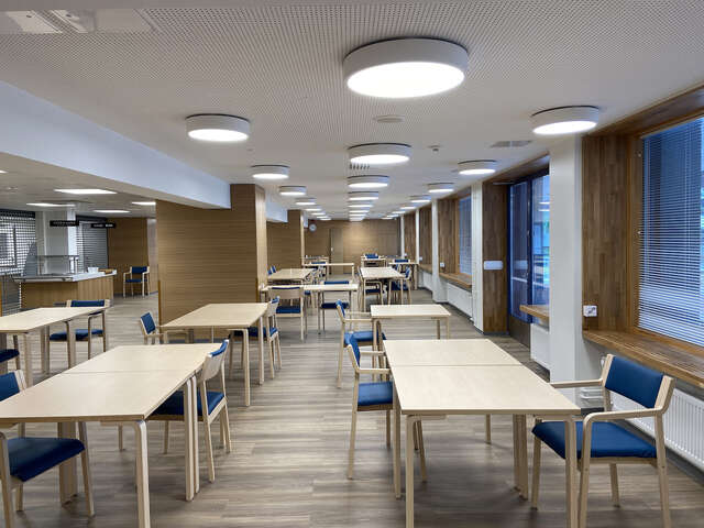A cafeteria with several tables and chairs.