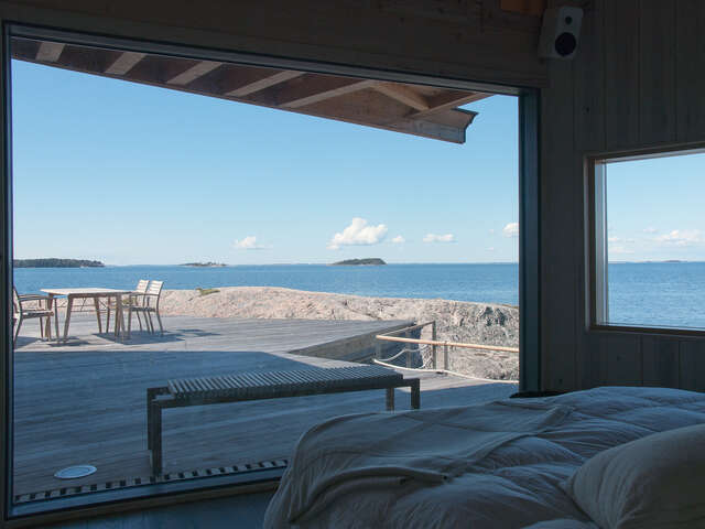 Bedroom view from a large window over the terrace and rock to the sea