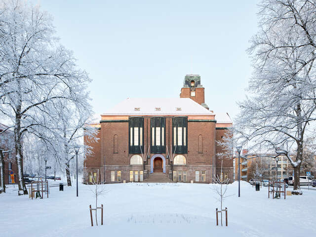 A large stone building in a park during winter