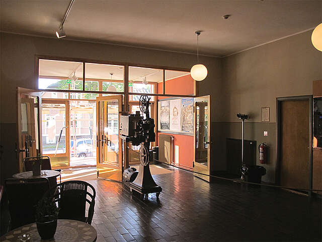 Neutral colored entrance hall with an old video camera and movie posters.