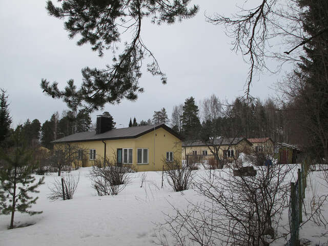 Yellow one-storey houses in a snowy landscape.