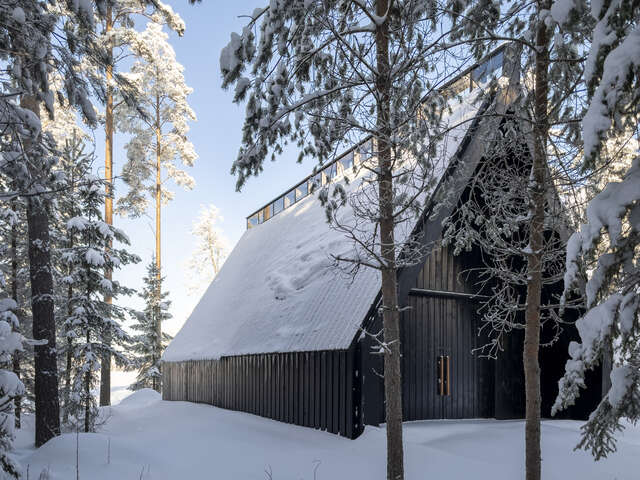 Lots of snow, a pitched roof of a dark-coloured building