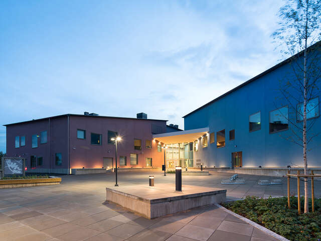 School facade with a red and a blue wing, both with different side offset windows.