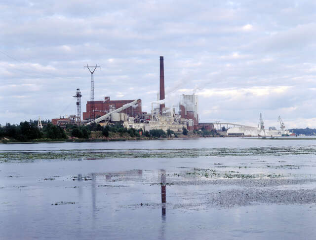 Red brick mill area with reflections on the sea in front