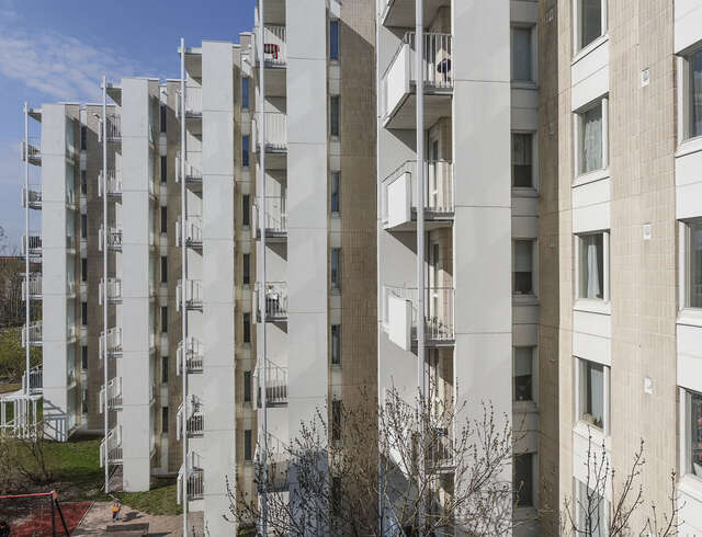 Stepped apartment buildings with brown tile and white panel elements.