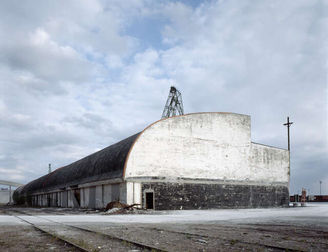 White warehouse building with an arched roof