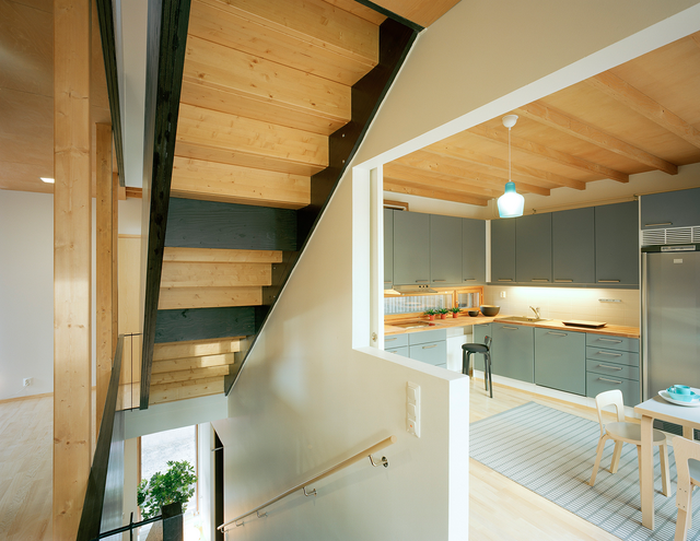 Photo inside the building. There are stairs and a kitchen.