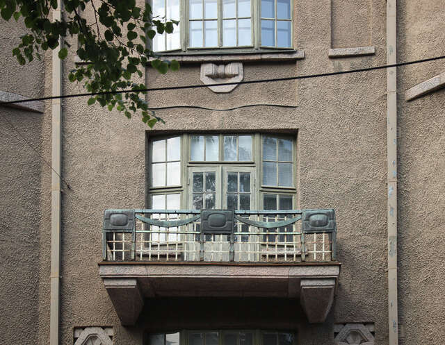 Small balcony with copper decorative elements at the top of the railing.