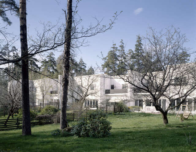 Garden side view to the white apartment block