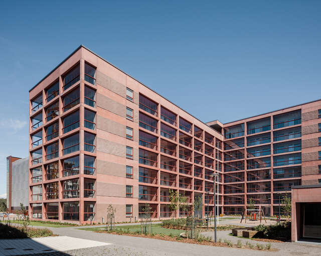 A red apartment building with rectangular balconies.