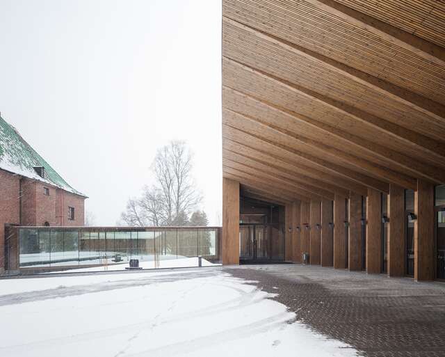 The wooden roof extends over the side of the building and protects from the snow.