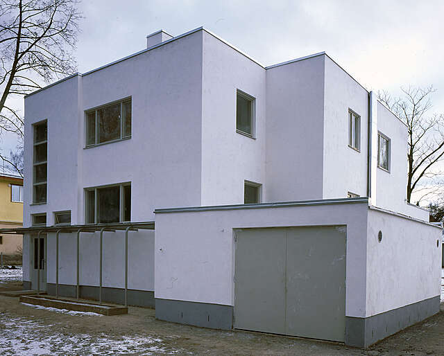 White two-story villa with square windows, flat roof and a garage