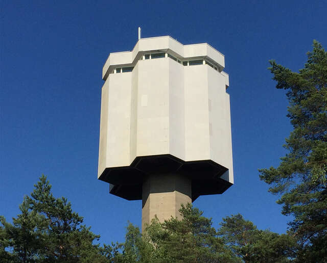 Water tower in brutalist style building has a honeycomb-shaped hexagon distributor reservoir.