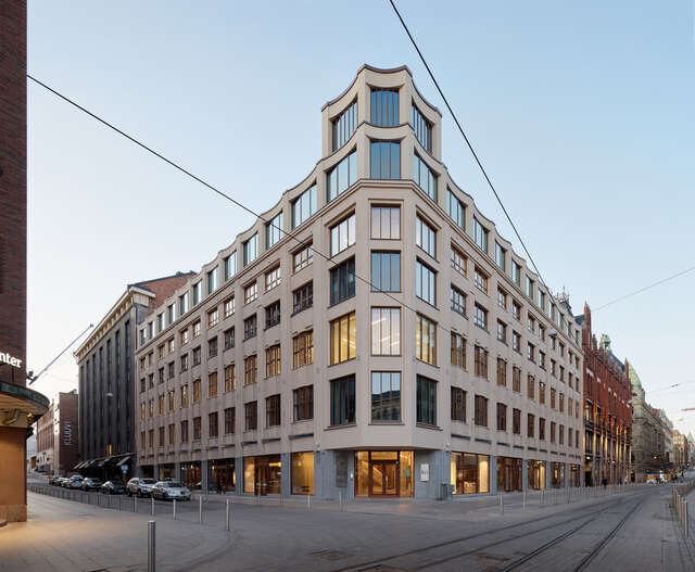 A large, multi-story stone building in an urban area.