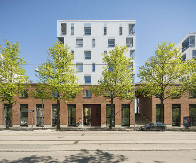 Red-brick building white white upper floors.