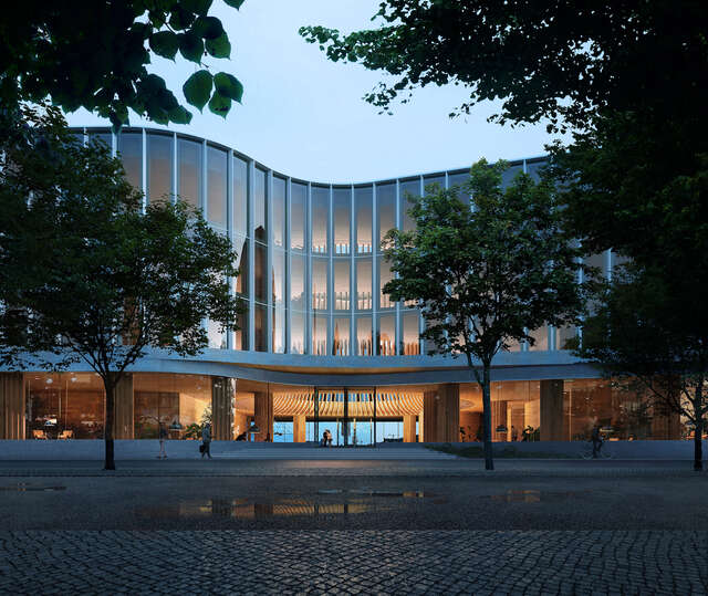 Building's entrance as seen from the street. Trees and park in the foreground.