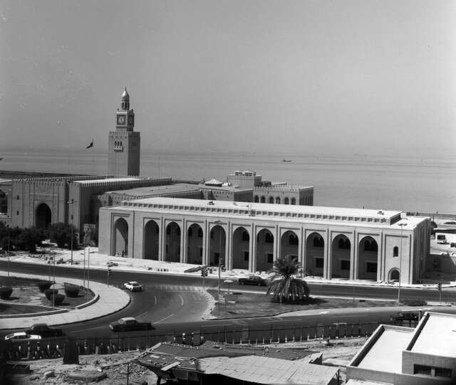 Palace with a tower and the extension with arch details next to the sea.