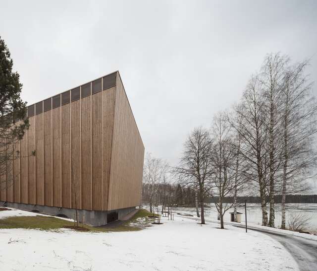 building with a wooden exterior and a slanted wall, no visible windows in a snowy landscape.