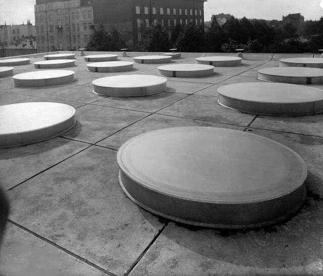 large flat cylinders on the roof of a building.