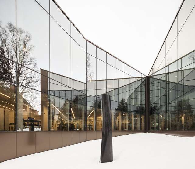 Sculpture engulfed by the mirrored sides of the building.