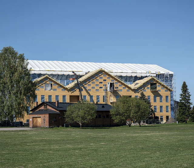 Exterior of the building with trees and grass field in front of it