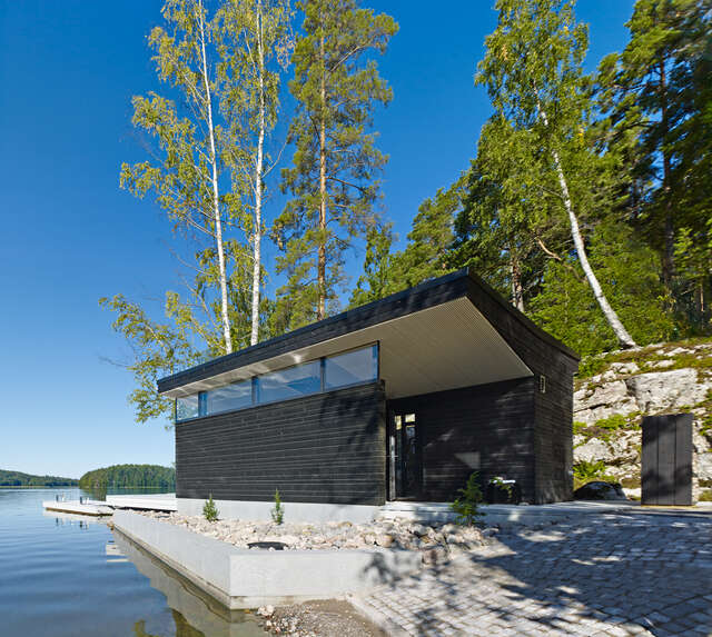 Black wooden building and ribbon windows looking to the sea