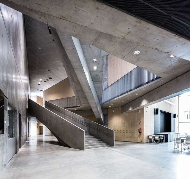 Industrial interior with concretetaires, wooden and metal walls and grid ceilings.