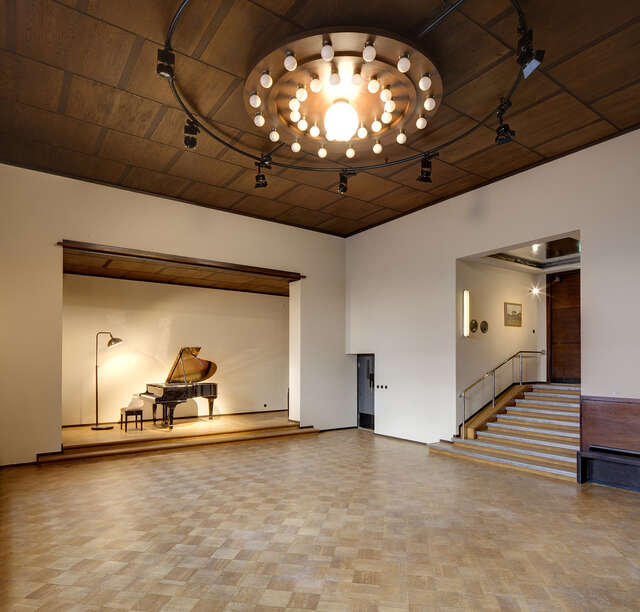 Hall with a grand pino on stage.