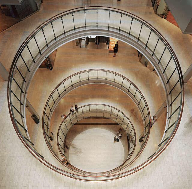 Circular hole in the floors with glass railings.