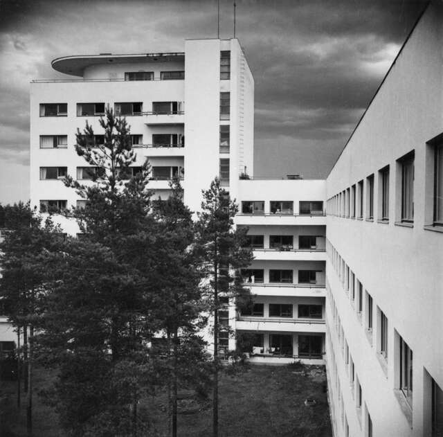 Functionalist hospital building surrounded by woods.