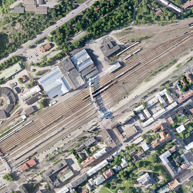 An aerial view of a curved bridge over a railway.