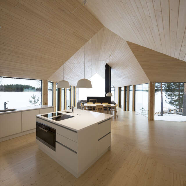 An interior picture, kitchen island and dining area with windows opening to the lake.