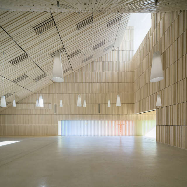 Spacious interior with vibrantly profiled wood panel used for the walls and ceiling, the colourful glass art gives the space a tranquil feeling.