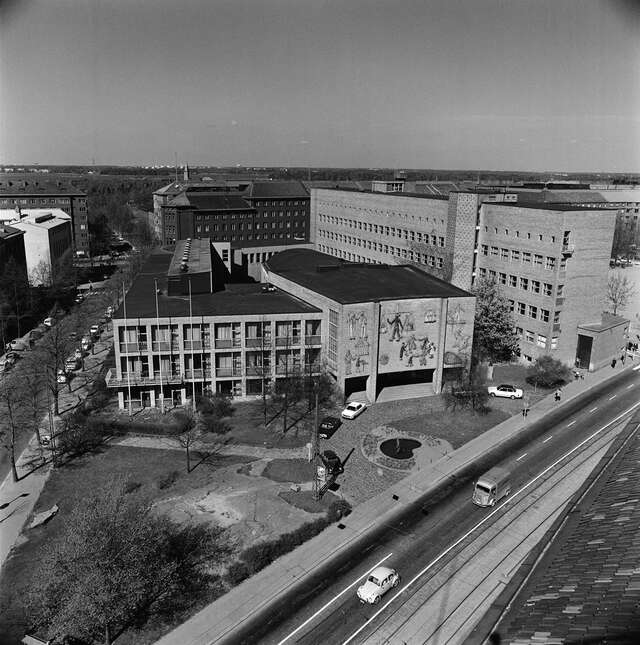 Aerial view of the building, cars in front of it trees around the building