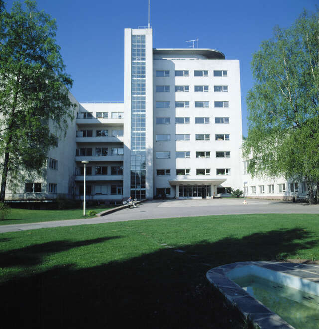 Functionalist hospital building surrounded by woods.
