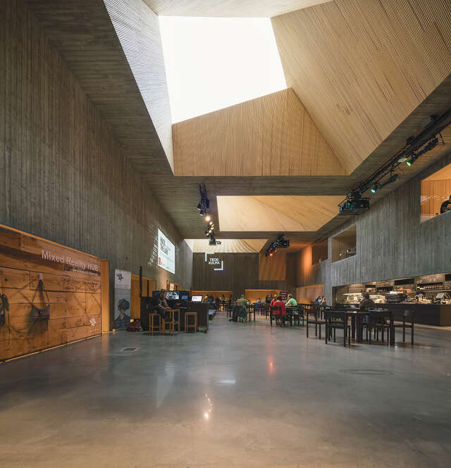 Spacious wood and concrete hall with a cafeteria.