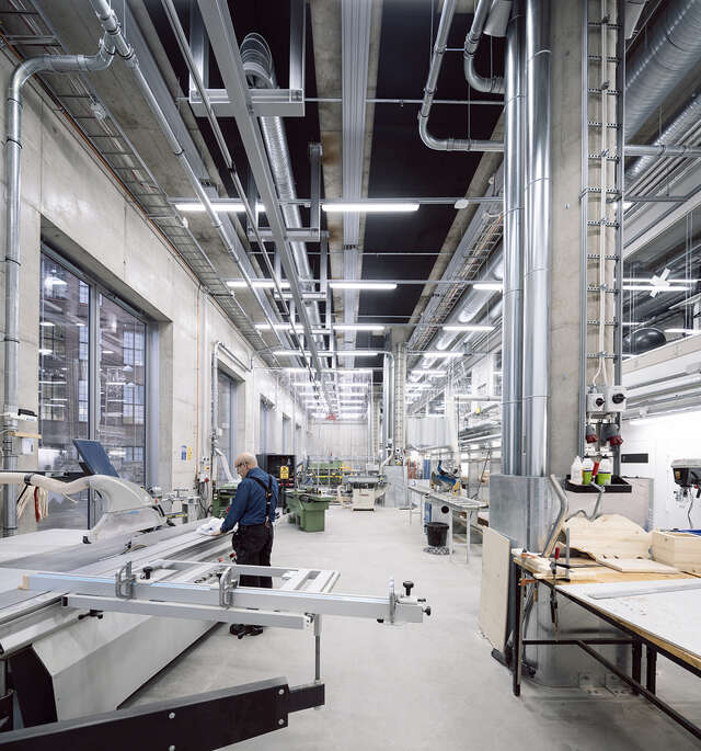Large hall with machines similar to a factory. One person standing in center of image.