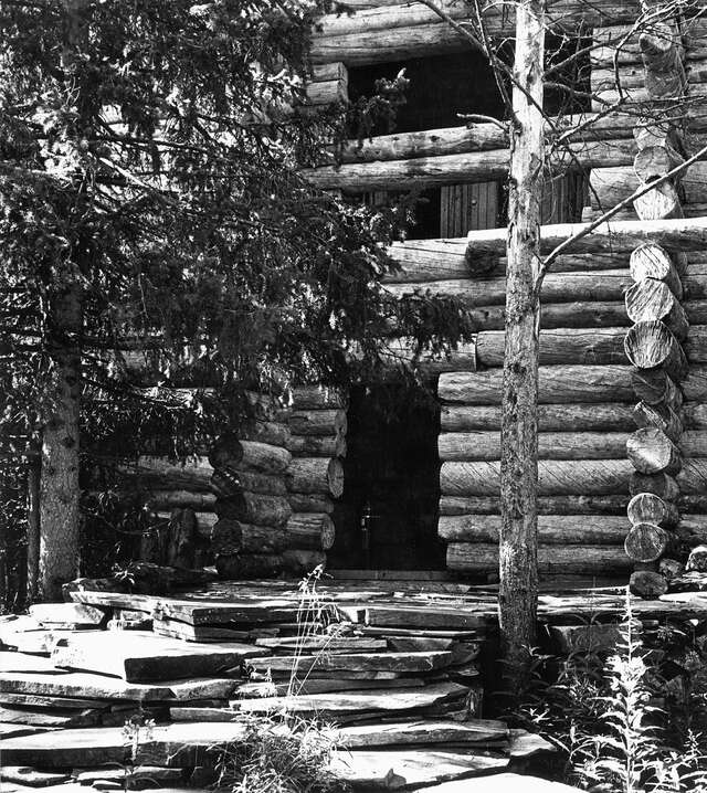 Facade and entrance with unhewn logs cut at different lengths in the corners.